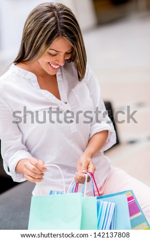 Female shopper holding shopping bags and looking happy