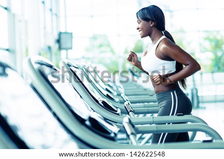 Woman running on a treadmill at the gym