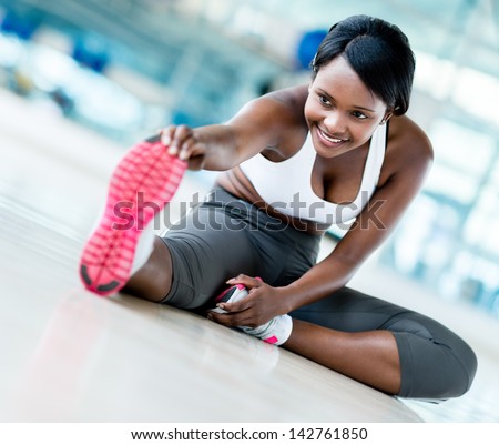 Gym woman stretching her leg for warm-up
