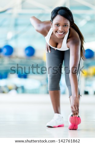 Gym woman stretching before her workout looking happy