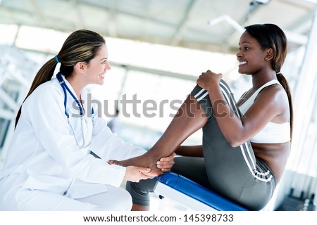 Gym Doctor With A Patient Checking Her Ankle