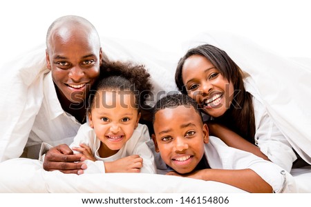 Beautiful happy family in bed - isolated over a white background