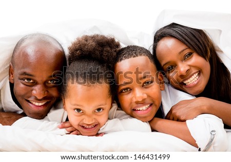 Happy family in bed under the covers - isolated over white