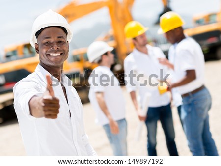 Happy engineer with thumbs up at a construction site