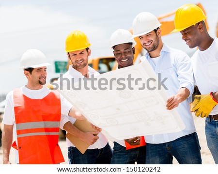 Group of workers at a construction site looking at blueprints