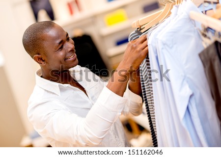 Happy man shopping for clothes at a store