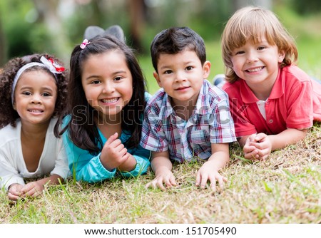 Happy group of kids playing at the park  - stock photo