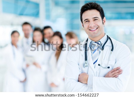 Happy Doctor With Medical Staff At The Hospital