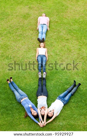 Group of people lying down making an arrow - outdoors