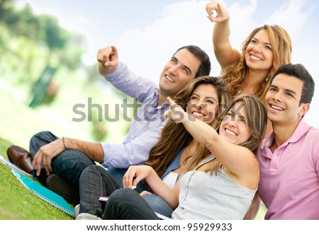 Group of friends at the park pointing away and smiling