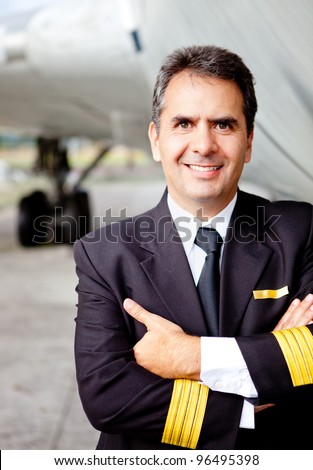 Friendly commercial pilot with an airplane at the backaground