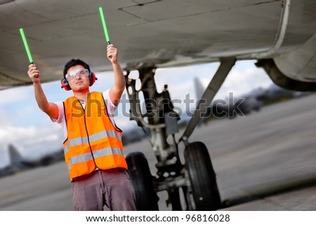Air traffic controller holding light signs at the airport