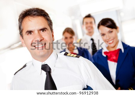 Captain with cabin crew in an airplane smiling