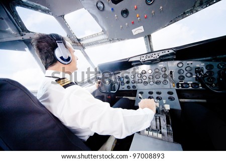 Pilot in an airplane cabin flying a plane