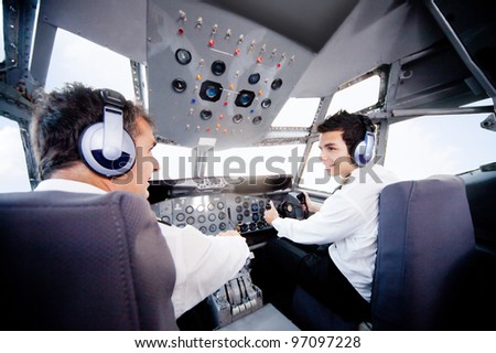 Pilots inside a cabin flying an airplane
