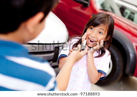 Excited girl buying a car at the dealer and looking at keys