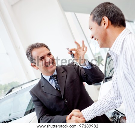 Salesman handling keys to a man after buying a car  stock photo