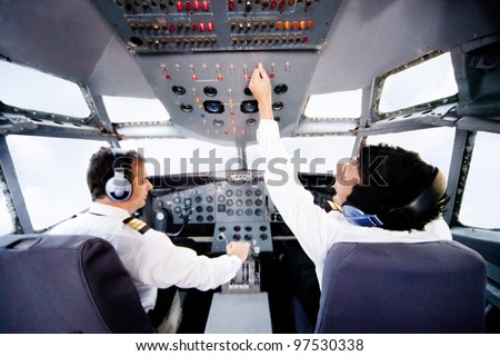 Pilots inside a cabin flying an airplane