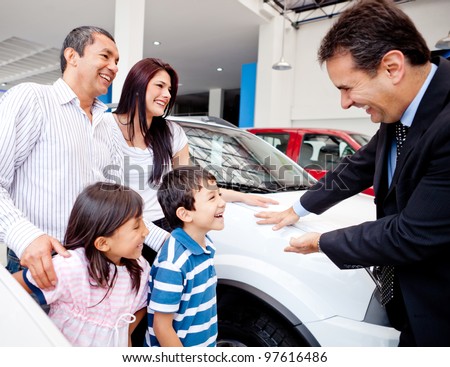 Happy family with the dealer buying a new car