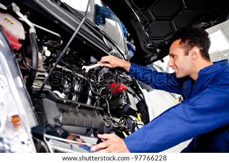 Car mechanic fixing a broken engine at the garage
