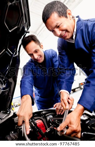 Team of mechanics fixing a car at the garage