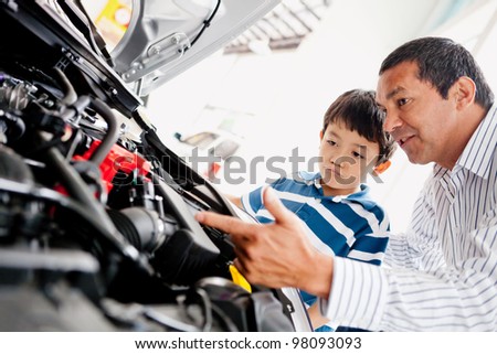 Father buying car with his son and explaining to him about mechanics