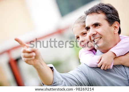 Father and girl pointing away and smiling - outdoors
