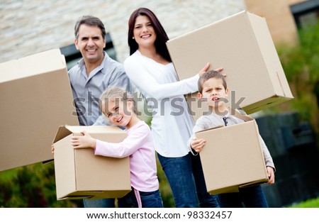 Family moving house and carrying cardboard boxes