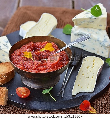 cheese plate with tomato chutney on the wooden table