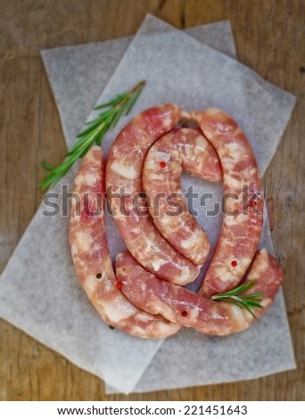 crude sausages ready for frying on a pig-iron frying pan.selective focus