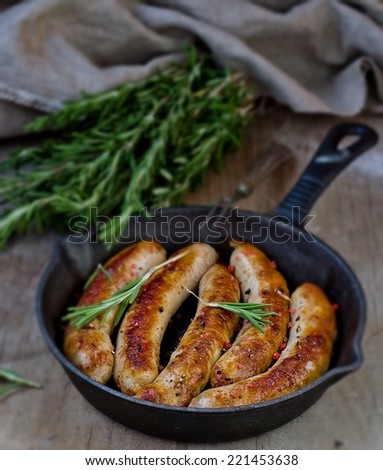 fried sausages on a frying pan on a wooden background.selective focus