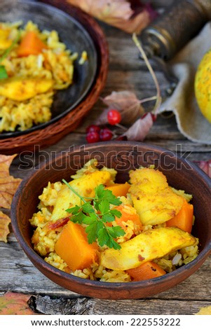curry rice with pumpkin and fish on an autumn background with pumpkins and fallen leaves.selective focus