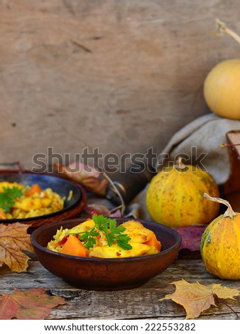 curry rice with pumpkin and fish on an autumn background with pumpkins and fallen leaves.selective focus
