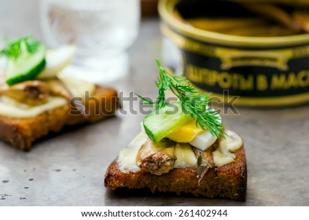 toasts with tinned sprats. traditional Russian festive dish. style vintage. selective focus