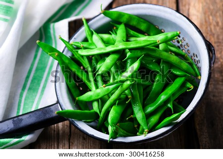 fresh, organic green beans in a vintage colander on a wooden table. style rustic. selective focus