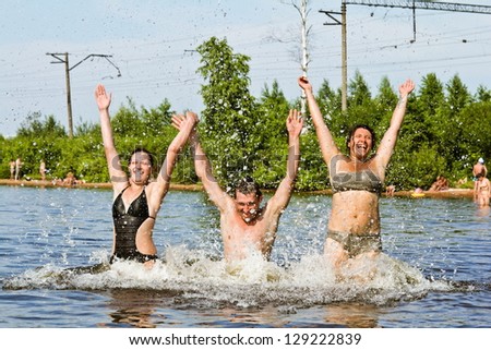young people jump and splash around in the Lake