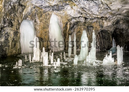 Cave with a frozen lake in the marble quarry Ruskeala in Karelia in the winter. Russia
