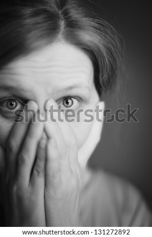 The surprised or scared woman covering her mouth by her hands.