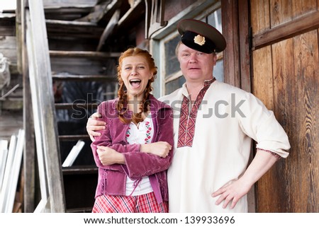 Russian couple in national costume on a porch
