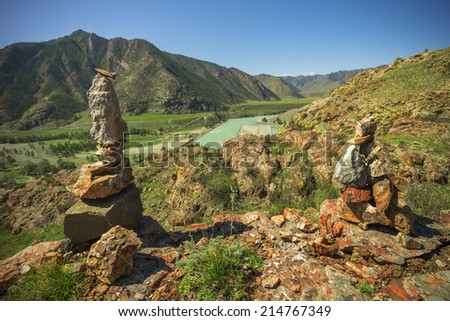 Pyramid of stones on a background of mountains on the observation deck at the confluence of the rivers Katun and Chewie, the Republic of Altai Mountains