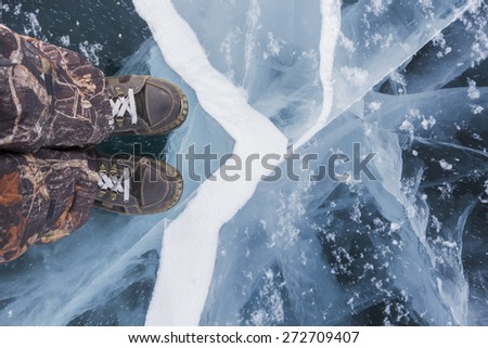 Human feet in boots on the ice Baikal