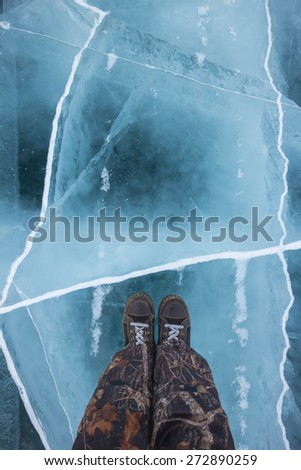 Human feet in boots on the ice Baikal