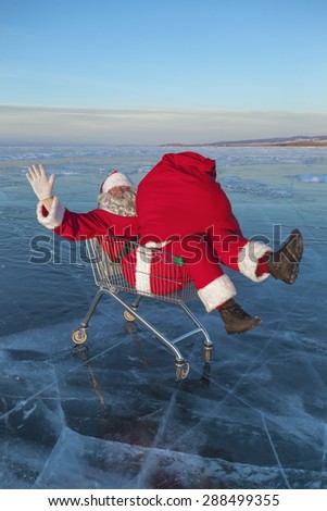 Santa Claus in the truck with a bag of gifts on winter lake ice