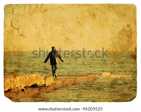 The man in black jacket is on the stone pier in the sea. Old postcard, design in grunge and retro style