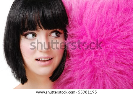 Funny close-up shot of a cute brunette girl reacting to the fluffy pillow-monster