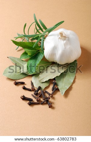 Still-life with assorted spices and herbs - garlic, mint, cloves, rosemary and bay leaves