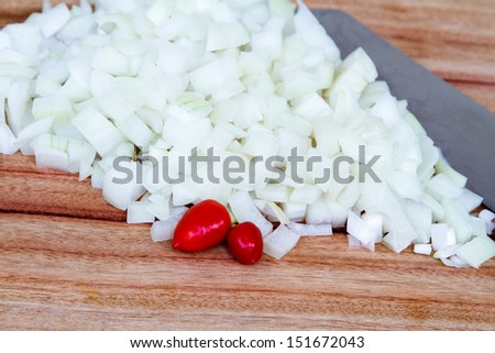 Mound of Diced White Onion with Knife and Chillis.  Close up of freshly chopped white onion with chef\'s knife and two red chilis