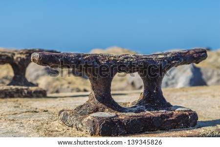 A large old rusty boat dock cleat