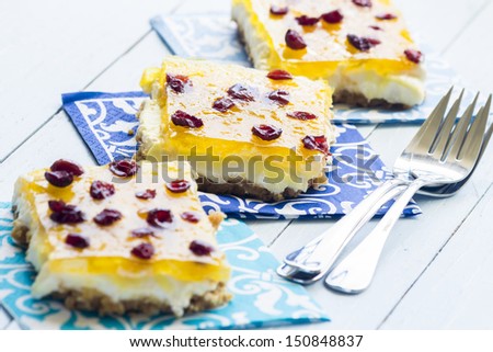 Hawaiian pineapple bars made with a graham cracker crust, cream cheese and marshmallow filling, jello and crushed pineapple topping, and sprinkled with dried cranberries