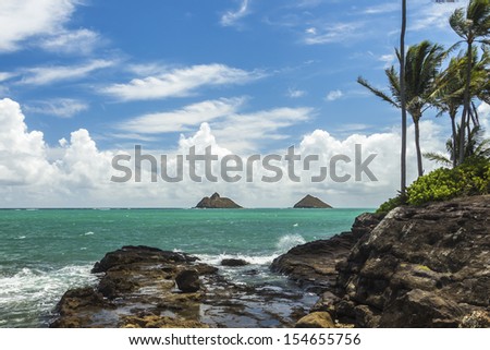 A view of Na Mokulua islands, also known as The Mokes and The Twins, from a rocky coastline in Lanikai, Oahu, Hawaii